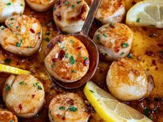 a pan filled with cooked scallops and lemon wedges