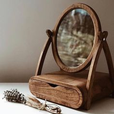 a wooden vanity mirror sitting on top of a table next to a pair of scissors