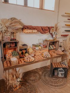 an assortment of food is displayed on a table in front of a sign that says candy bar