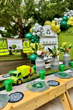 a table topped with vases filled with flowers and green cups on top of it