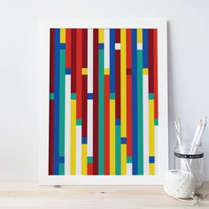 an art print with multicolored lines on it next to a crochet hook