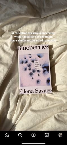 the book blueberries by ellena savaze is laying on a bed with white sheets