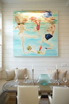 a painting on the wall above a dining room table