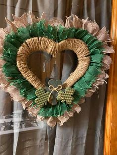 a heart shaped wreath hanging from the side of a window