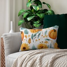 a white couch sitting next to a green plant