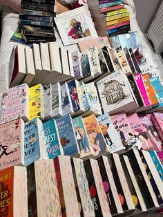 a pile of books sitting on top of a bed