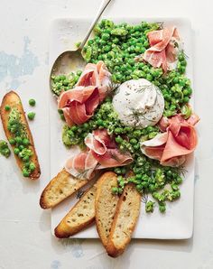 a white plate topped with bread and peas