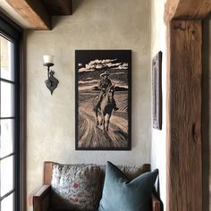 a living room filled with furniture and a painting hanging on the wall next to a window