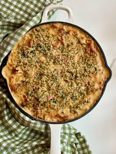 a casserole dish with meat and cheese in it on a green checkered cloth