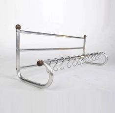 a metal rack with several hooks hanging from it's sides on a white background