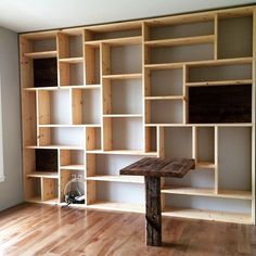 a wooden table sitting in front of a bookshelf filled with lots of shelves