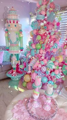 a pink and blue christmas tree with lots of ornaments on it's branches in a living room