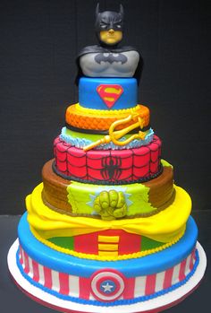 a multi - tiered cake decorated with batman and superman symbols