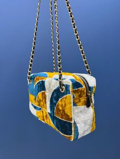 Indulge in luxury with our stunning gold chained shoulder strap bag. This handcrafted bag is made with the finest silk velvet fabric that feels soft and velvety to the touch. The shoulder strap is crafted with leather chains that add a touch of edginess to the overall design. Measuring at 15x20 cm with a bellows of 10 cm, this bag is the perfect size to carry all your daily essentials. The silk velvet fabric gives it a glamorous and sophisticated look that is perfect for any occasion. The gold c Luxury Velvet Rectangular Shoulder Bag, Gold Velvet Bag For Gifts, Gold Velvet Gift Bag, Gold Velvet Rectangular Bag, Gold Velvet Clutch Evening Bag, Luxury Gold Velvet Bags, Elegant Pillow, Silk Velvet Fabric, Yellow Silk