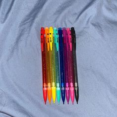 several pens are lined up on a sheet