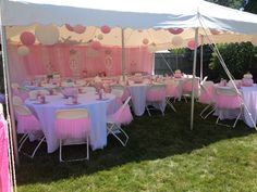 tables and chairs are set up under a tent for a baby's first birthday party