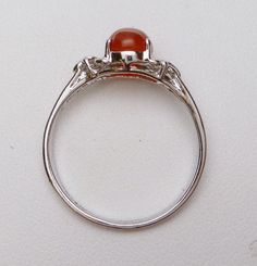 This is a very cute little silver ring :) The ring features an oval cabochon cut carnelian that measures 8 x 6 mm. The carnelian is a red/brown color and opaque. The sides of the ring have a cut out design that kind of looks like a bow. The ring is stamped 925 and weighs 1.3 grams. The ring is rhodium plated and is a size 7.5. Oval Carnelian Moonstone Ring For Anniversary, Classic Orange Oval Cabochon Rings, Diamond Wedding Sets, Cut Out Design, Oval Cabochon, Red Brown, Diamond Wedding, Rhodium Plated, Brown Color