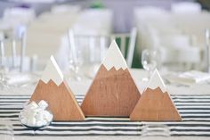 three wooden mountains sitting on top of a table next to white plates and silverware