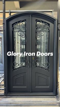 an iron double door with glass panels on the sides and side panels on the top