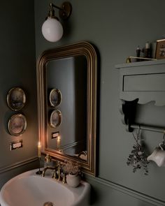 a bathroom sink sitting under a mirror next to a wall mounted faucet with lights on it