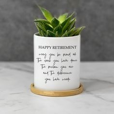 a plant in a white ceramic pot that says happy retirement