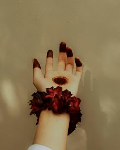 a woman's hand with red flowers on it