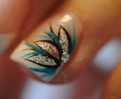 a woman's hand with some blue and white nail art designs on her nails