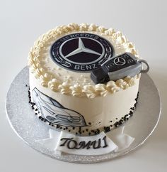 a white and black cake with a mercedes emblem on it