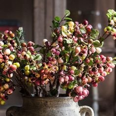 a vase filled with lots of flowers on top of a table