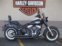 a black motorcycle parked in front of a harley davidson sign