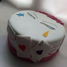 a birthday cake decorated with playing cards and hearts