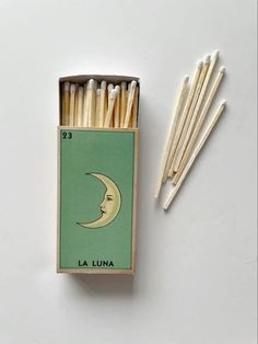 an unopened box of matches with the moon on it next to some sticks