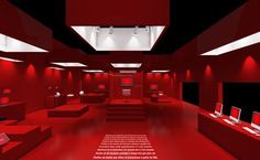 a red room with laptops and other items on the tables in it, all lit up