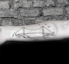 a man's arm with a drawing of a bridge on it