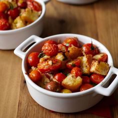 two white bowls filled with food on top of a wooden table