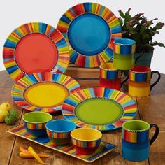 brightly colored dishes and cups on a wooden table