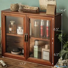 a wooden cabinet with glass doors and shelves filled with perfumes, books, and other items