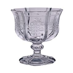 a clear glass bowl with an ornate design on the top and bottom, sitting on a white background