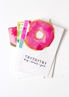 three watercolor donuts on top of each other with the word try written in black