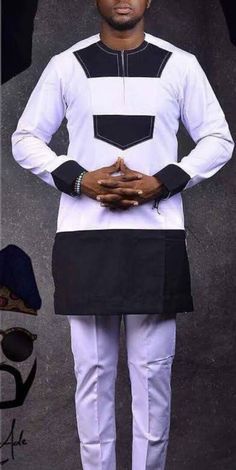 Introducing our authentic African two-piece suit - perfect for any formal occasion and showcasing the beauty of traditional African clothing. Crafted from 100% pure quality fabric and featuring impeccable stitching, this set is designed with your comfort in mind for ultimate style and sophistication. The versatile white color with black detailing makes this suit suitable for all occasions and personalities. The round neck and long sleeves add a classic touch, while the button studs and executive finishing give it a polished look. The regular fit of the suit is complemented by the slim fit pant, creating a sleek and modern silhouette. Each piece is 100% handmade and authentically African, ensuring the highest quality and originality. The comfortable 100% cotton fabric is perfect for all-day Mens Traditional Wear, Dashiki Outfit, Dashiki For Men, African Suit, Nigerian Men Fashion, African Wear Styles For Men, Traditional African Clothing, Latest African Men Fashion, African Attire For Men