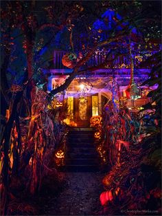 an entrance to a house decorated for halloween with pumpkins on the steps and trees