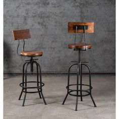 two wooden and metal barstools in front of a concrete wall