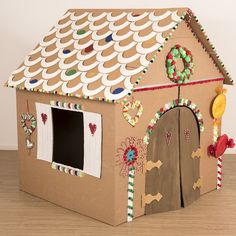 a cardboard gingerbread house with candy decorations on the roof