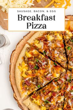 sausage, bacon, and egg breakfast pizza on a wooden platter with serving utensils