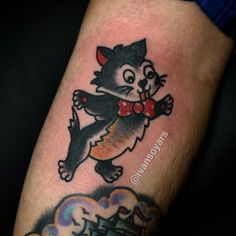 a cat with a bow tie tattoo on his arm