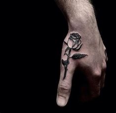 a man's hand with a rose tattoo on it