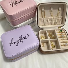 three small jewelry boxes with rings and bracelets in them sitting on a bed next to each other