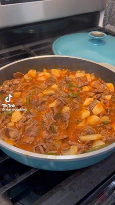 a pot filled with stew sitting on top of an oven