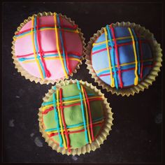 three decorated cupcakes sitting on top of a table