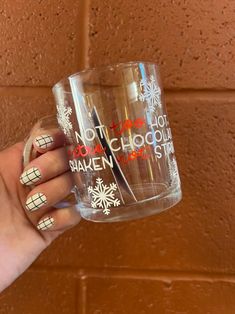 a woman's hand holding a coffee mug with holiday nail art on the inside